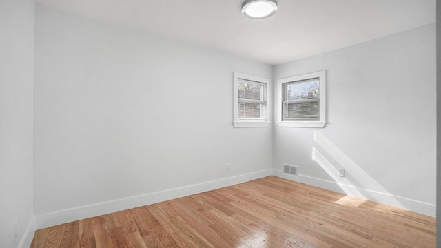 empty room featuring baseboards and light wood finished floors