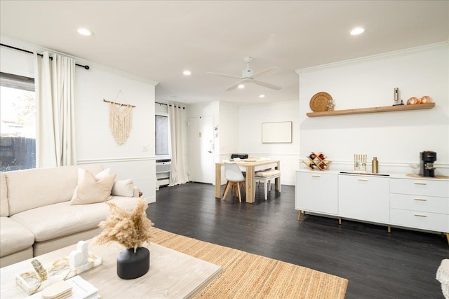 living area featuring dark wood finished floors, recessed lighting, crown molding, and ceiling fan