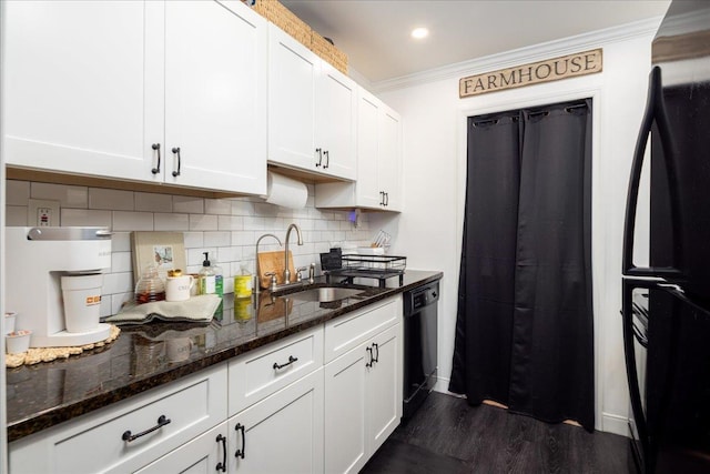 kitchen featuring backsplash, crown molding, white cabinets, black appliances, and a sink