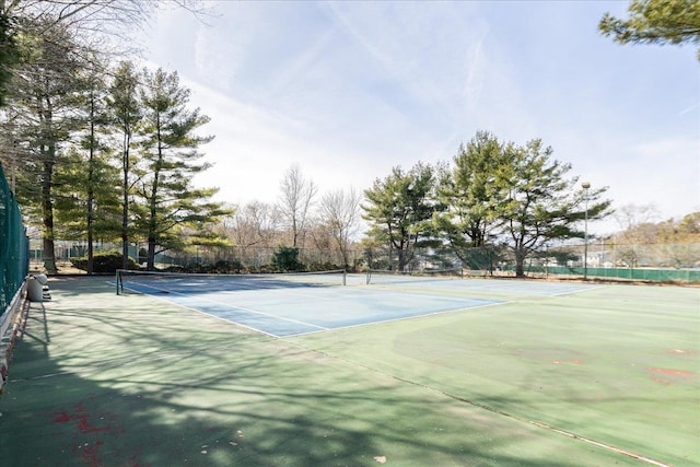 view of tennis court featuring fence