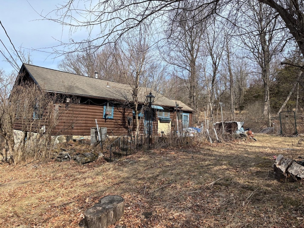 exterior space featuring a shingled roof