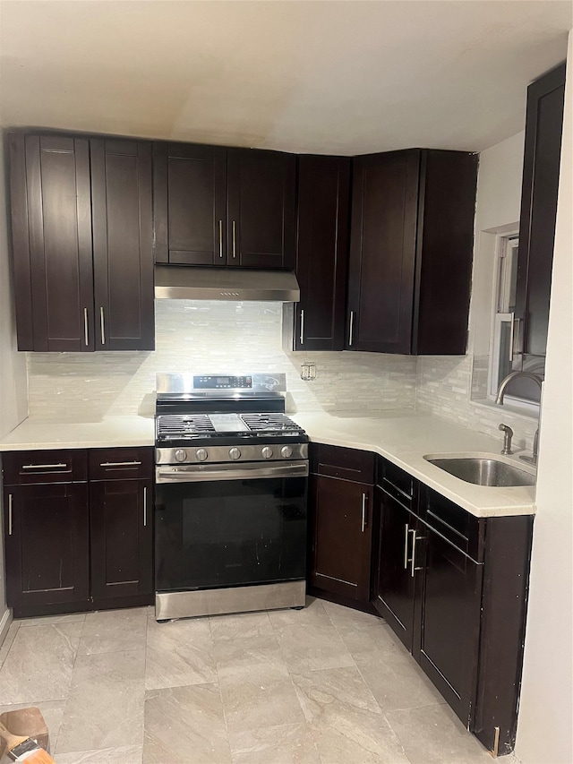 kitchen featuring light countertops, a sink, stainless steel range with gas cooktop, and under cabinet range hood