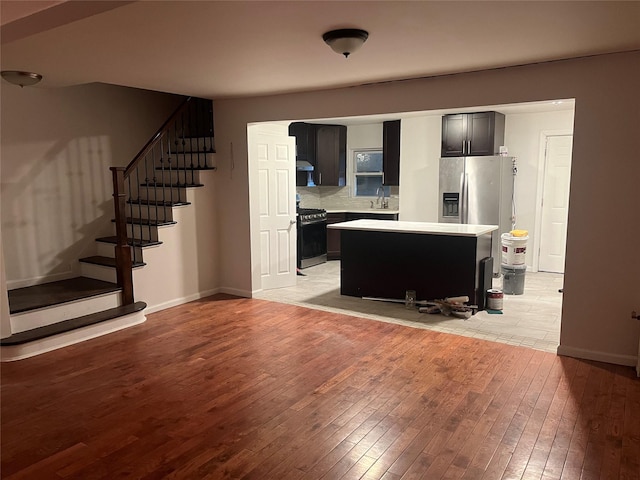 living room with baseboards, stairs, and light wood-type flooring