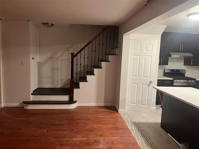 staircase with baseboards and wood finished floors