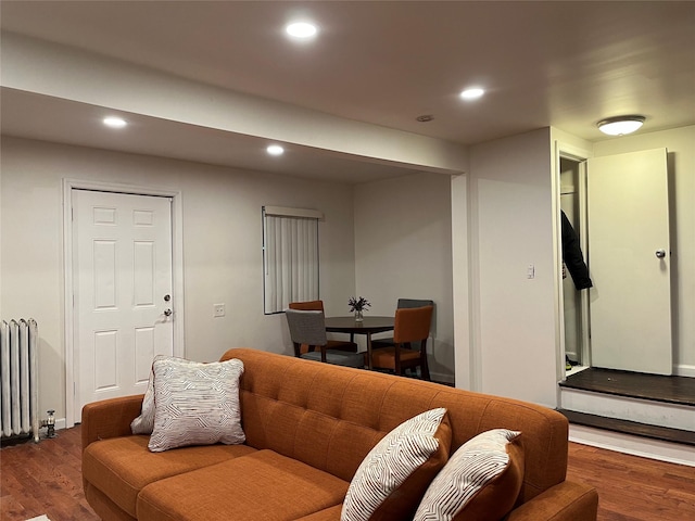 living area featuring recessed lighting, radiator, and wood finished floors