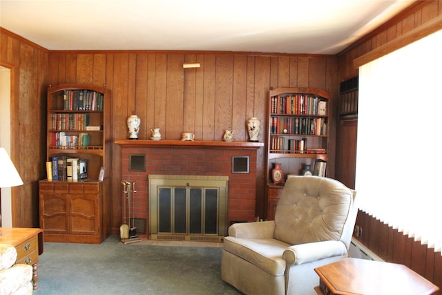 sitting room featuring wooden walls, carpet, visible vents, radiator heating unit, and a fireplace