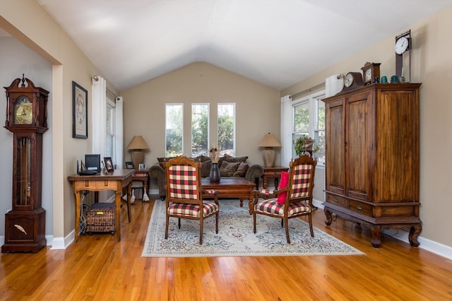 sitting room with vaulted ceiling, light wood-style floors, and baseboards