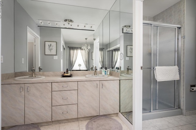 full bathroom featuring double vanity, a stall shower, and a sink