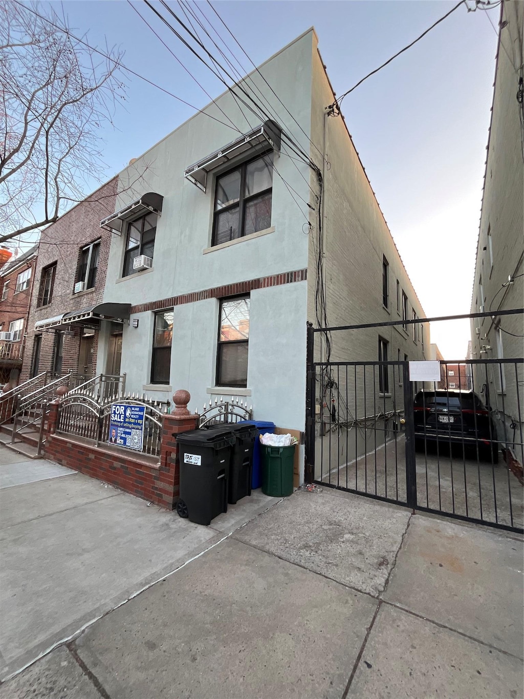 exterior space with stucco siding, fence, and a gate