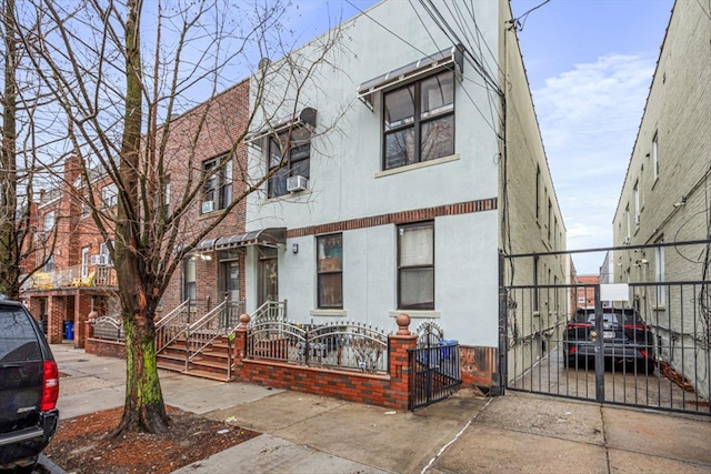 1715 Saint Peters Ave, Bronx, NY 10461 - view of property featuring a fenced front yard, driveway, stucco siding, and a gate