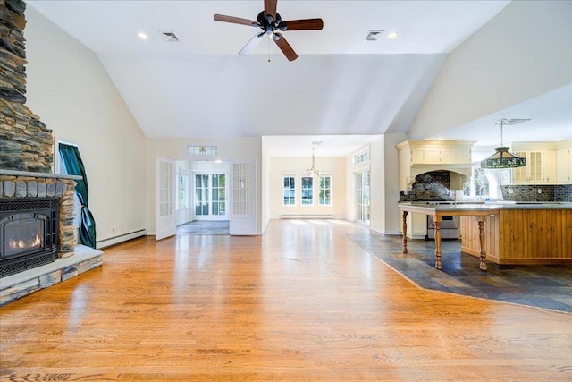69 Leber Rd, Blauvelt, NY 10913 - living room with high vaulted ceiling, visible vents, a stone fireplace, and baseboard heating