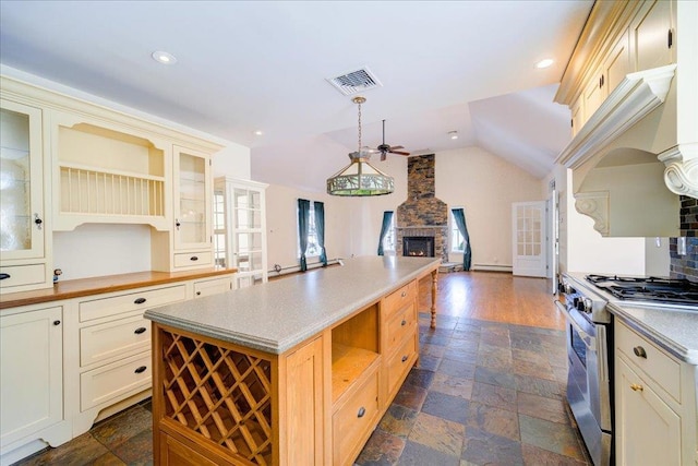69 Leber Rd, Blauvelt, NY 10913 - kitchen with open shelves, a fireplace, stainless steel range with gas stovetop, stone finish flooring, and visible vents