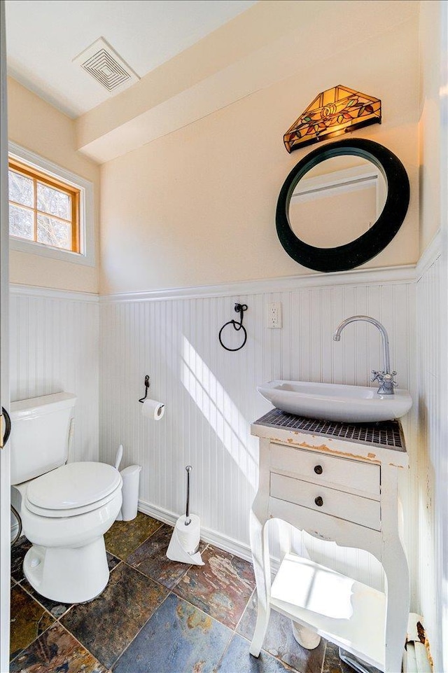 69 Leber Rd, Blauvelt, NY 10913 - bathroom with stone finish flooring, wainscoting, toilet, and visible vents
