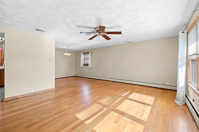 unfurnished room featuring ceiling fan with notable chandelier, plenty of natural light, light wood-style floors, and visible vents