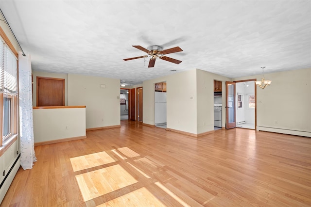 unfurnished living room featuring baseboards, baseboard heating, light wood-style flooring, and ceiling fan with notable chandelier