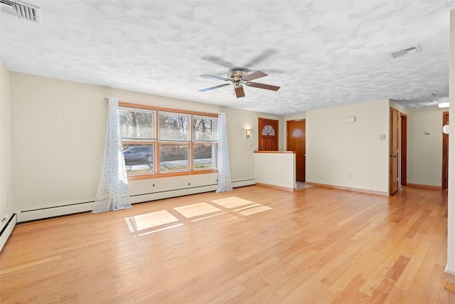 empty room with visible vents, light wood-style flooring, a textured ceiling, and ceiling fan