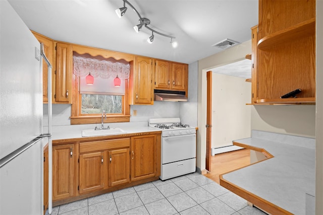 kitchen featuring visible vents, under cabinet range hood, light countertops, white appliances, and a sink