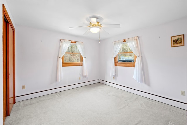 carpeted empty room with baseboard heating and a ceiling fan