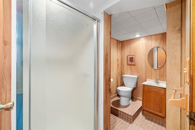 full bathroom with toilet, a stall shower, wood walls, tile patterned flooring, and vanity