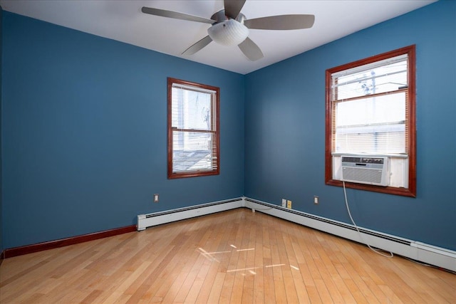 unfurnished room with a healthy amount of sunlight, cooling unit, a baseboard heating unit, and wood-type flooring