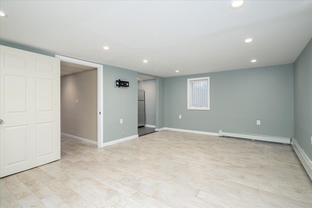 unfurnished room with recessed lighting, baseboard heating, light wood-style flooring, and baseboards