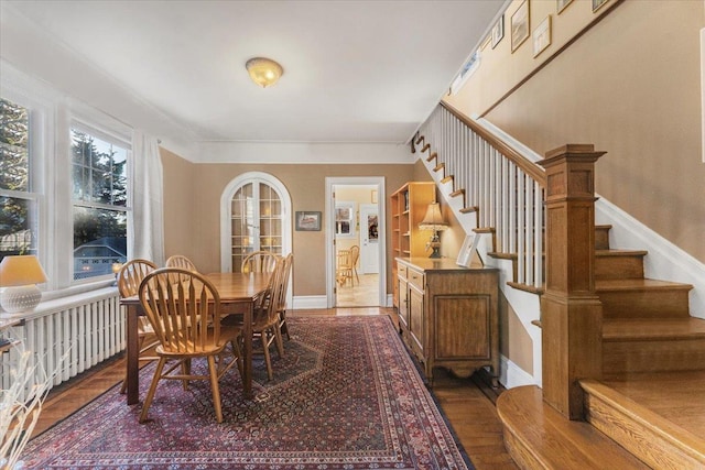 dining room featuring dark wood finished floors, stairway, and baseboards