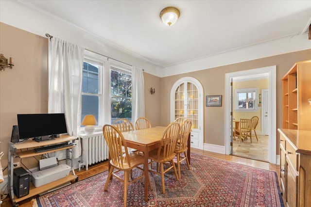 dining space featuring radiator, baseboards, and light wood-style floors