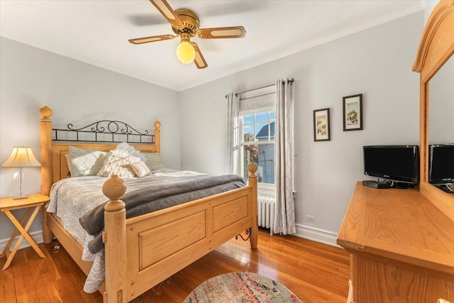 bedroom featuring dark wood-style floors, radiator heating unit, and crown molding