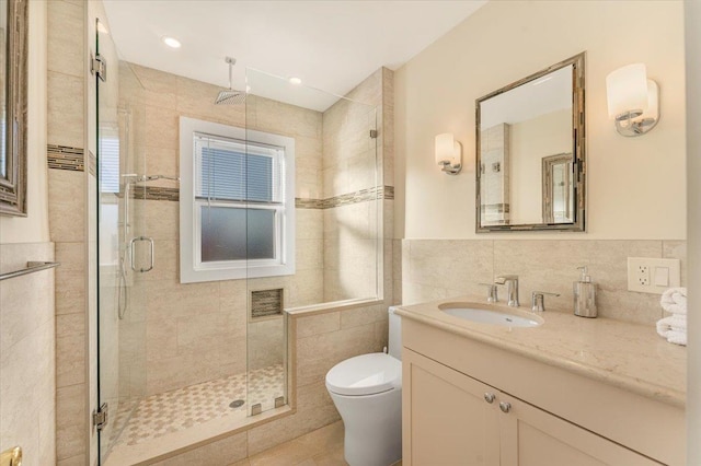 full bath featuring vanity, toilet, tile walls, and a shower stall