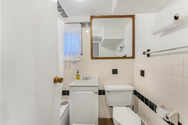 full bathroom with toilet, tile walls, walk in shower, and a sink