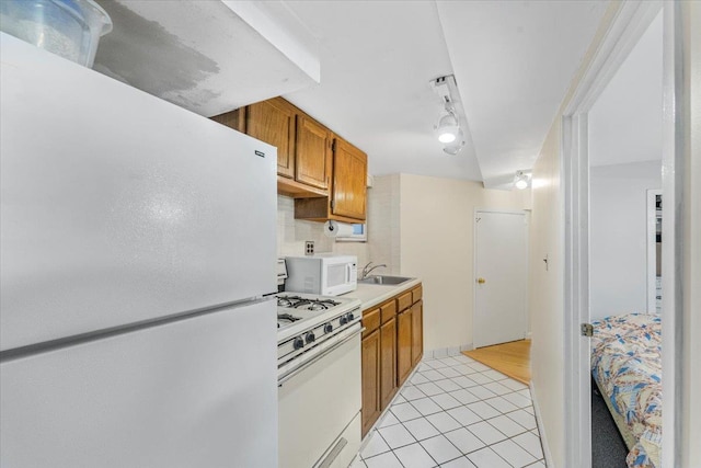 kitchen featuring brown cabinets, white appliances, light tile patterned flooring, light countertops, and decorative backsplash