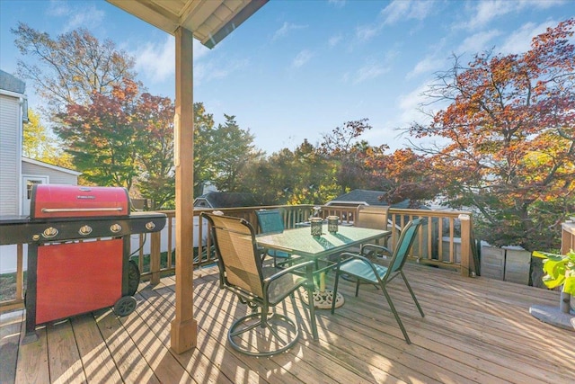 deck with outdoor dining space and grilling area