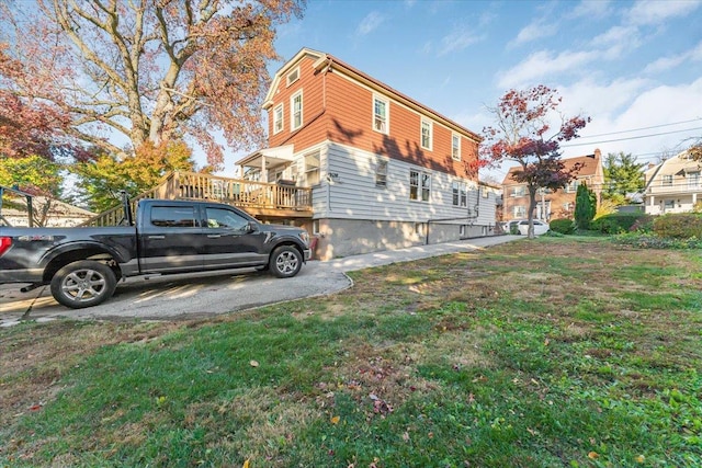 view of side of property with a deck and a yard