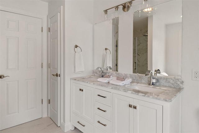 full bathroom featuring double vanity, a stall shower, and a sink