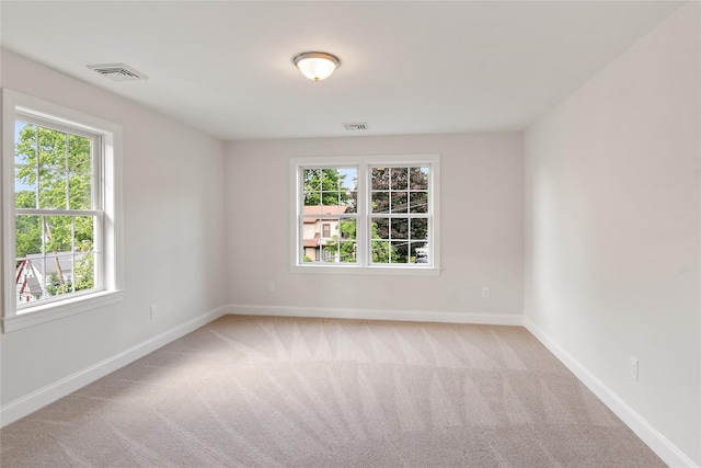 carpeted empty room featuring visible vents and baseboards