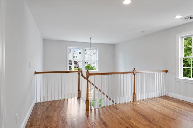 corridor featuring recessed lighting, wood finished floors, visible vents, and baseboards