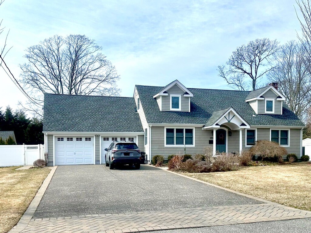 170 Gerritsen Ave, Bayport, NY 11705 - cape cod-style house featuring fence, a front yard, roof with shingles, a garage, and driveway