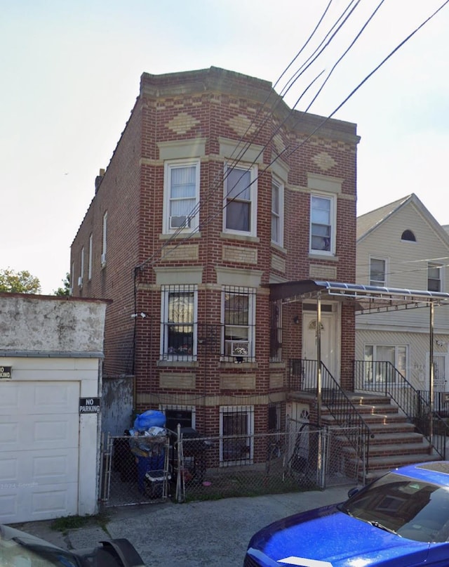 view of front of home featuring a fenced front yard, brick siding, and a gate