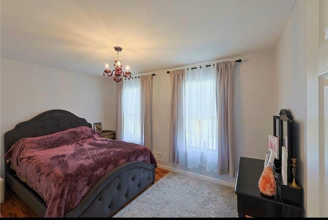 bedroom featuring multiple windows, baseboards, and a chandelier