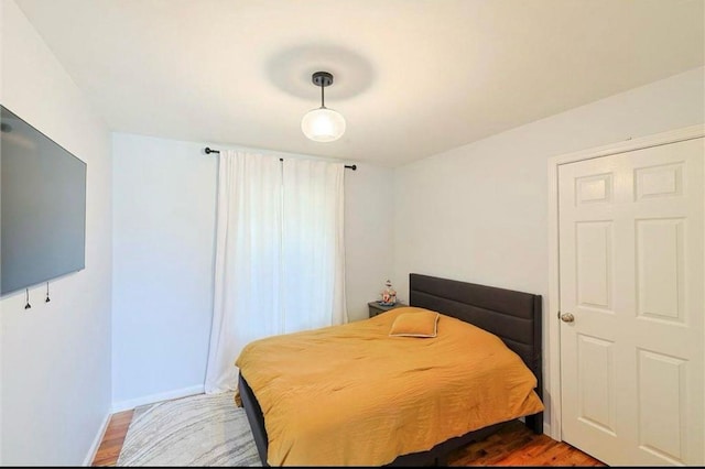 bedroom with baseboards and wood finished floors