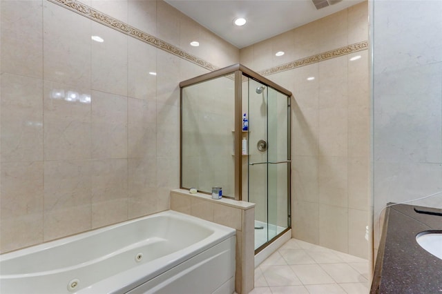 bathroom with tile patterned flooring, a stall shower, a tub with jets, tile walls, and a sink