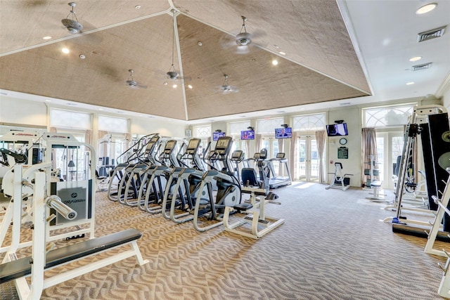 gym with a tray ceiling, carpet, visible vents, and high vaulted ceiling