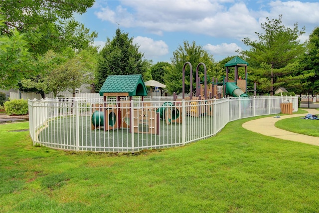 community play area featuring a yard and fence