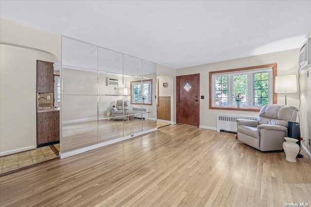 entrance foyer with radiator and wood finished floors