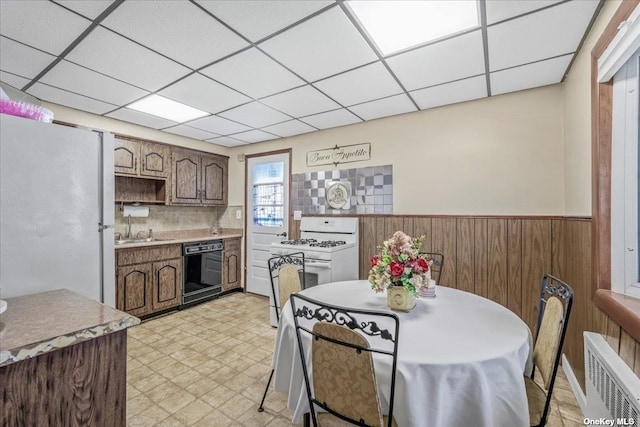 interior space featuring wainscoting, light floors, radiator, and a paneled ceiling