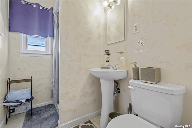 full bath with toilet, curtained shower, and wallpapered walls