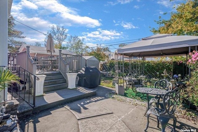 view of patio / terrace with area for grilling, a deck, a shed, a gazebo, and an outdoor structure