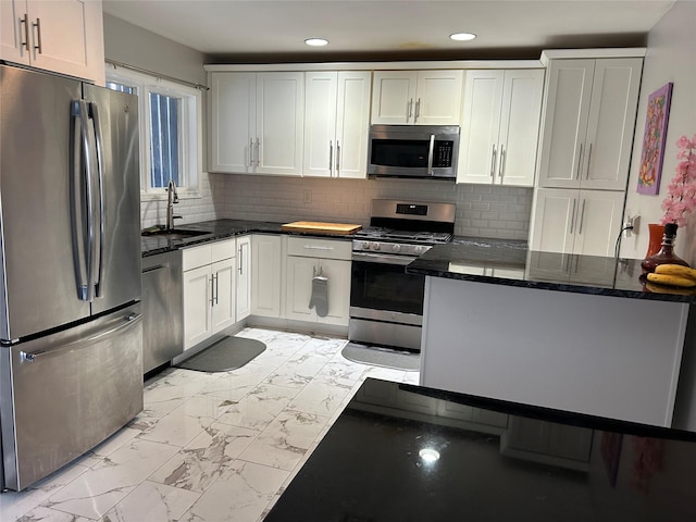 kitchen featuring marble finish floor, a sink, recessed lighting, stainless steel appliances, and white cabinets