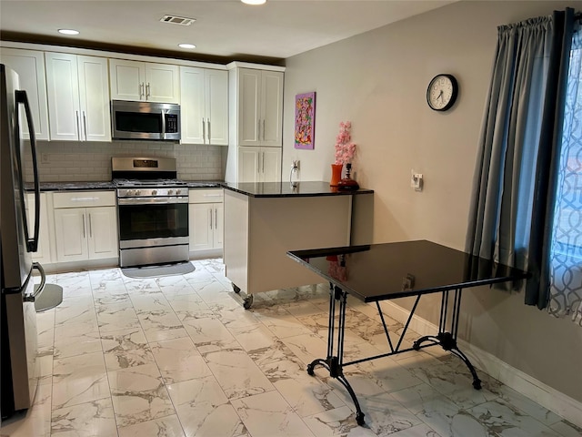 kitchen featuring white cabinets, marble finish floor, visible vents, and appliances with stainless steel finishes