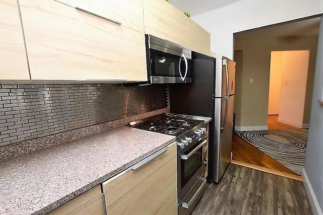 kitchen with dark wood-style floors, backsplash, stainless steel appliances, and baseboards